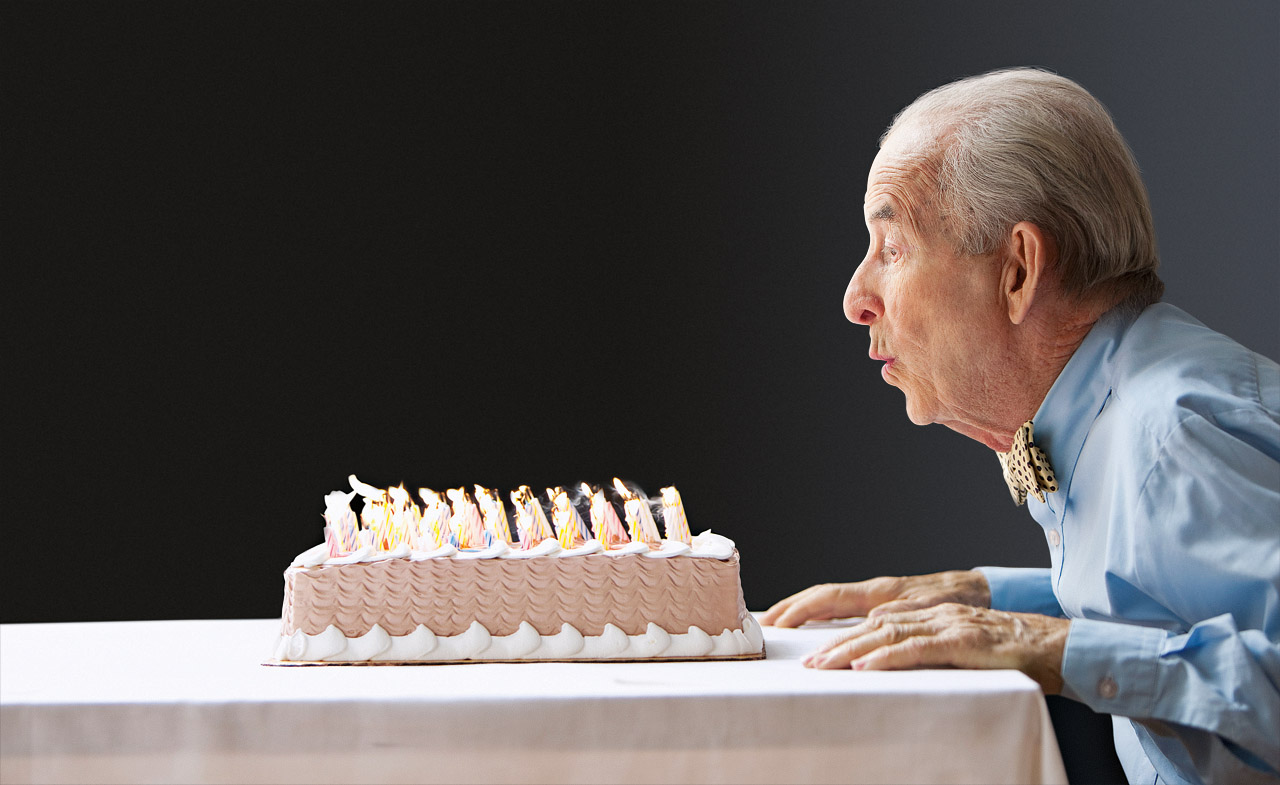 Old man retired blowing out birthday candles