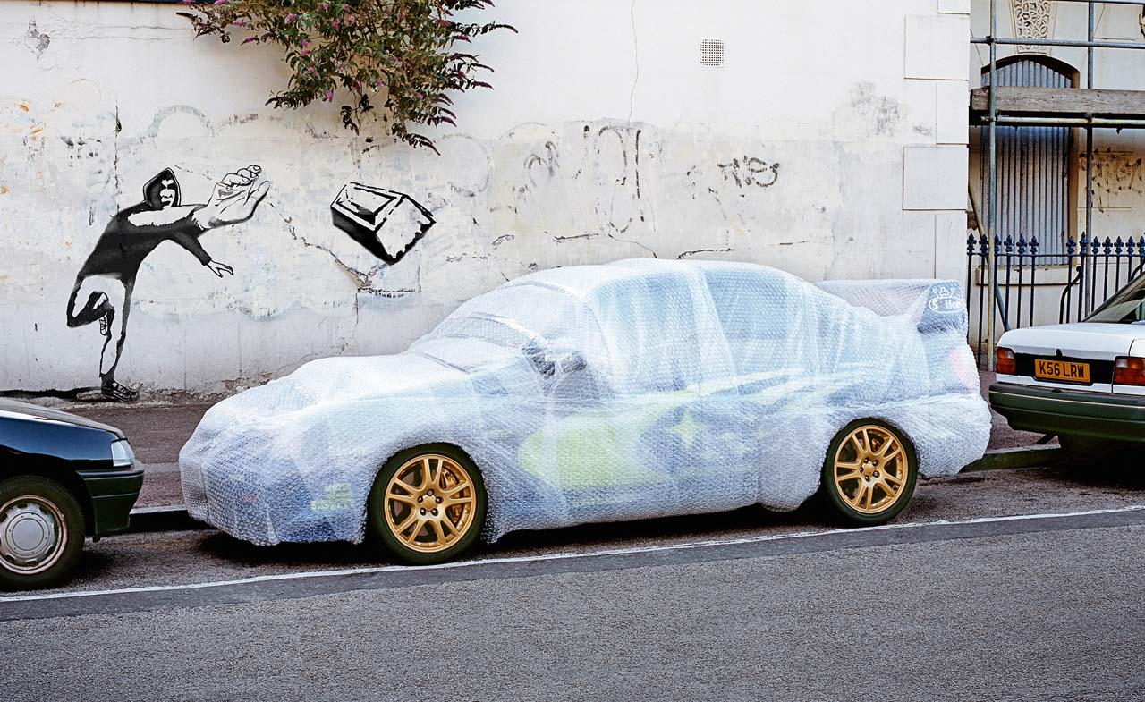Grafitti Throwing Brick At Bubble Wrapped Car